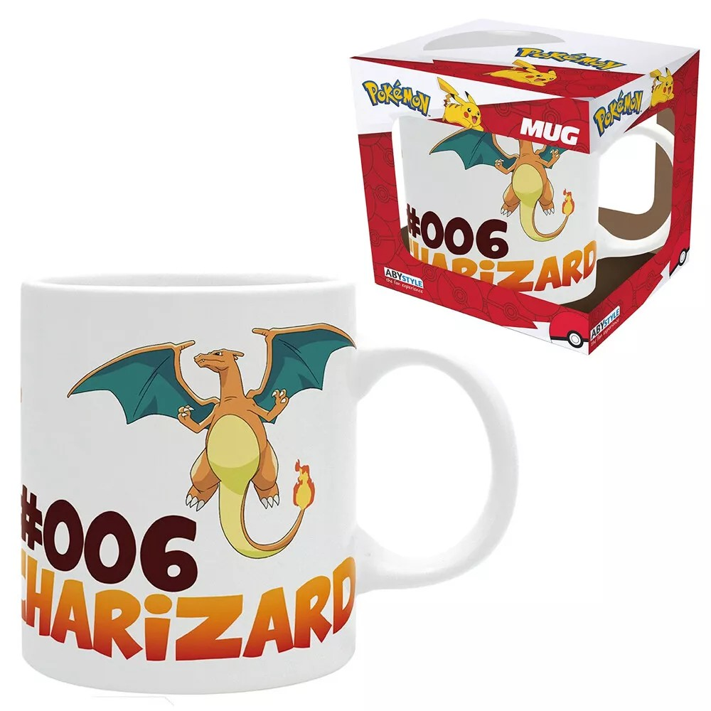 Image showing a white ceramic Charizard mug alongside its packaging. The mug features Charizard with the text '#006 CHARIZARD' in bold gradient lettering. The box packaging displays the same design with the Pokémon logo and Pikachu illustration on top. The box is red with Poké Ball details and the word 'MUG' prominently displayed.